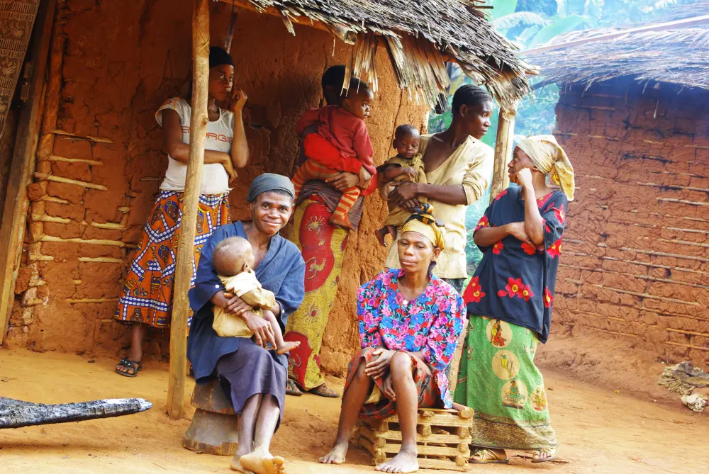 Femmes et enfants devant une case
